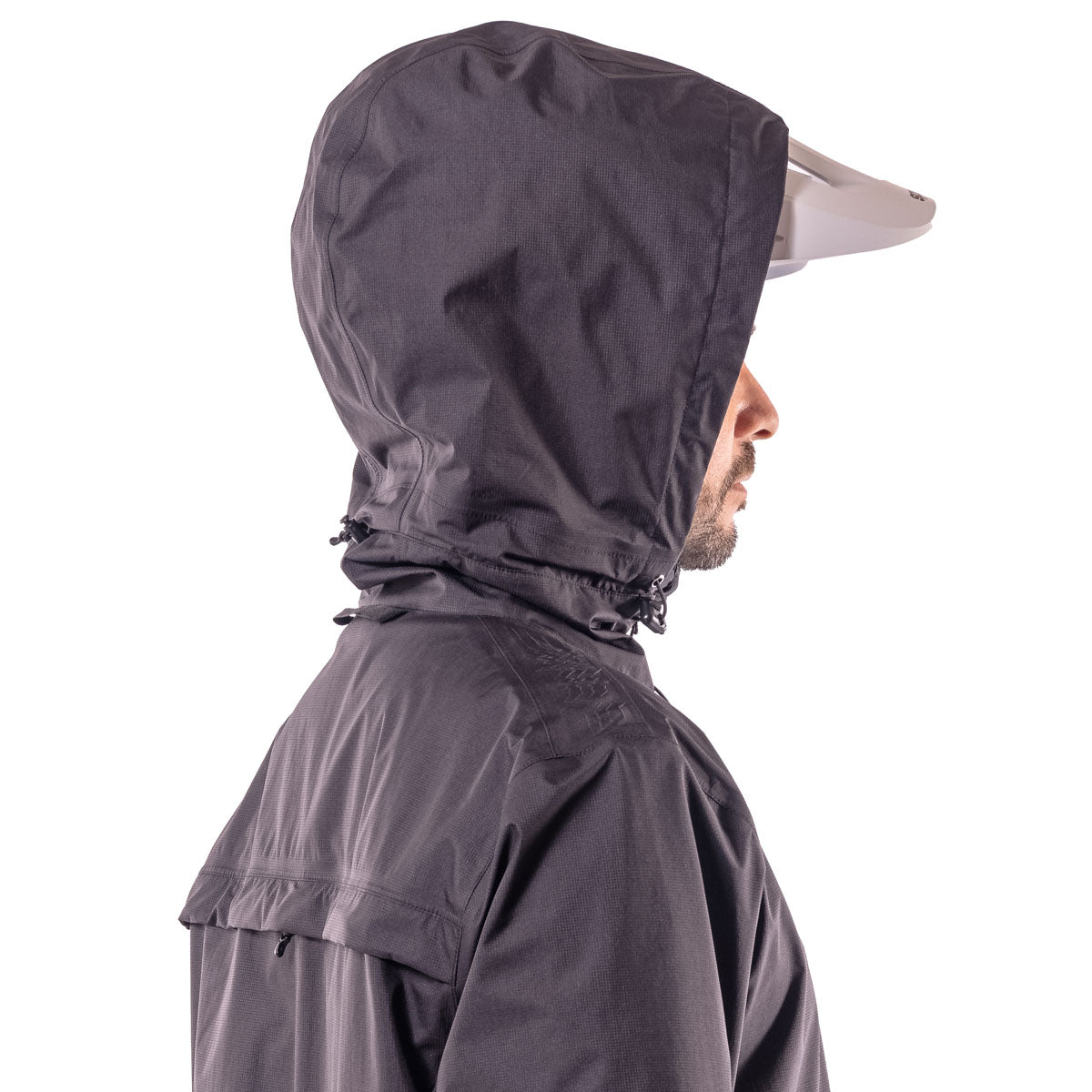 back of biker wearing hooded black jacket where the hood fits over the helmet