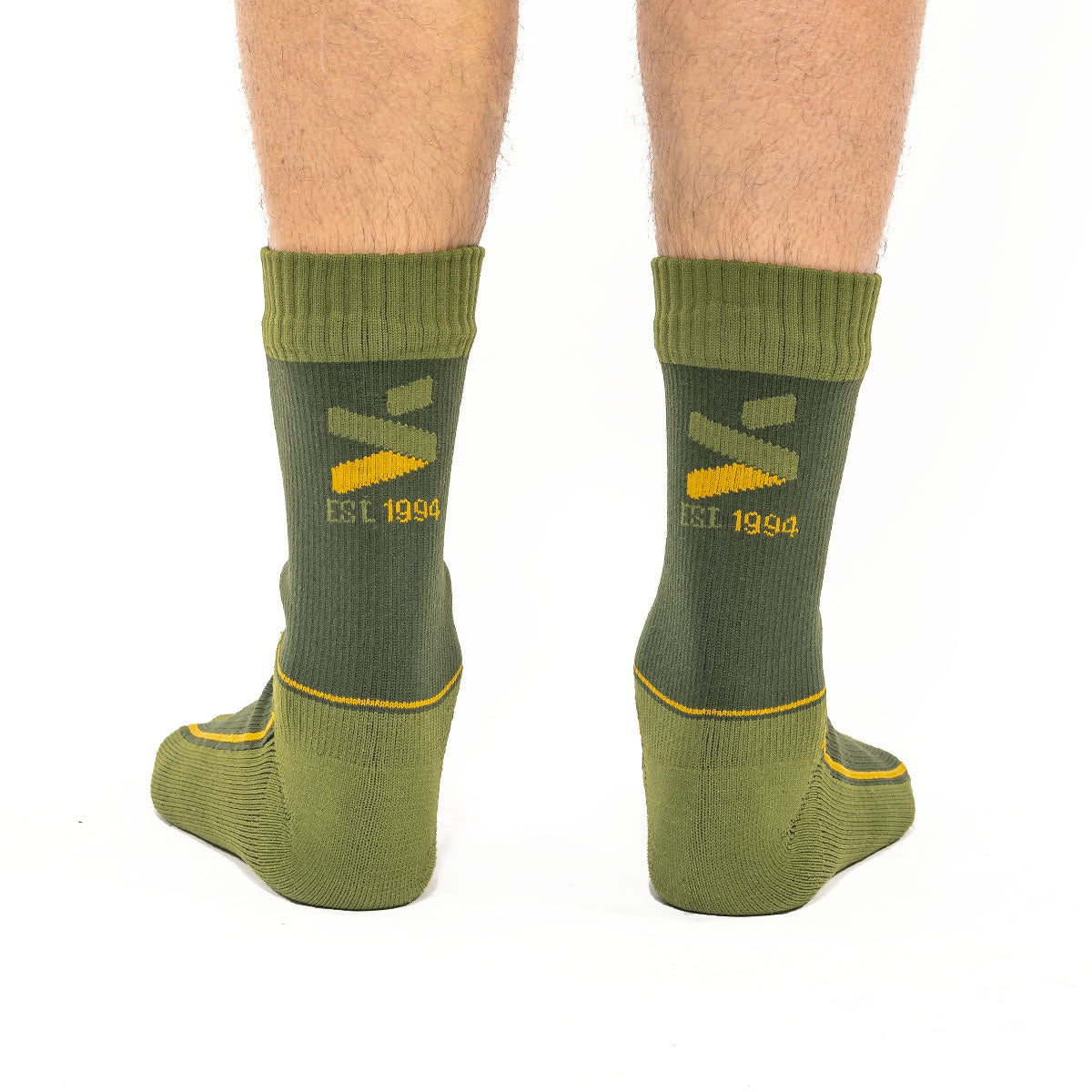 A pair of olive green MTB socks with yellow and black branding around the ankle area.