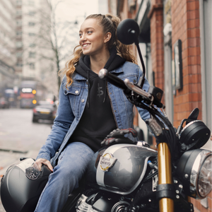 Grace Webb riding a motorbike wearing a ladies denim motorcycle jacket