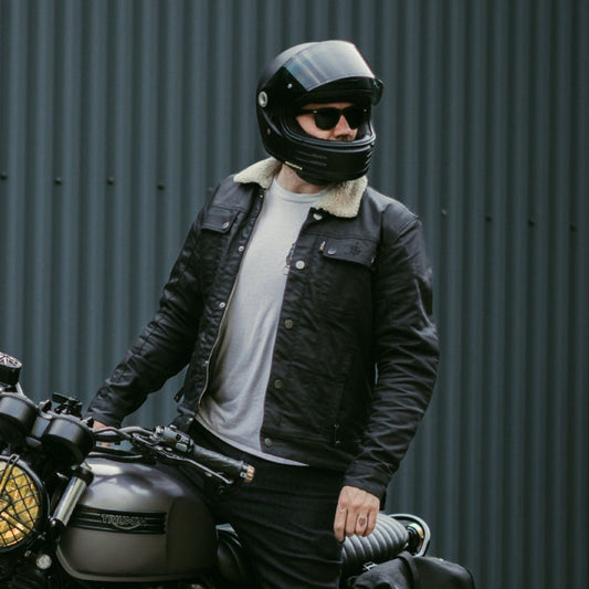 biker on motorbike wearing black motorbike helmet with autumn motorcycle jacket for men