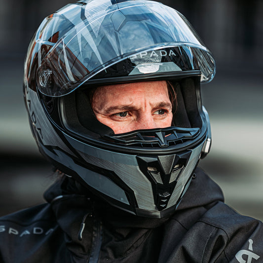 man wearing motorcycle helmet while riding with the front flipped up