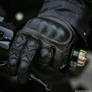 black leather motorcycle gloves with brown stitching worn by biker on a ride