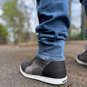 closeup of hem of washed blue motorcycle jeans for men