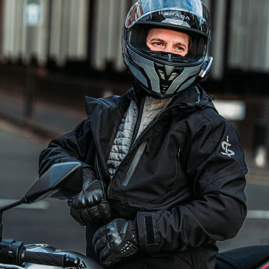 biker wearing spada black motorcycle helmet with black nodachi waterproof jacket