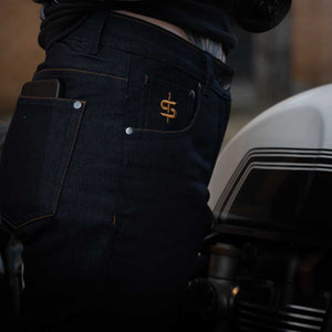 female biker wearing raw denim blue motorcycle jeans for women