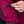 Close-up of a hand zipping up a magenta jacket with a blurred background