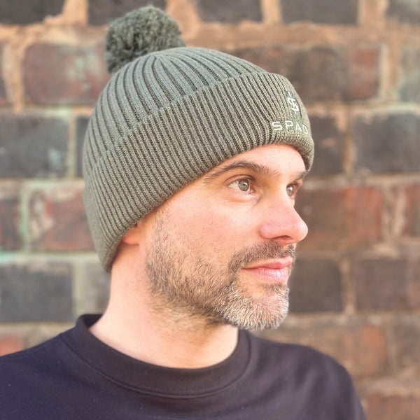 man wearing olive green bobble beanie hat