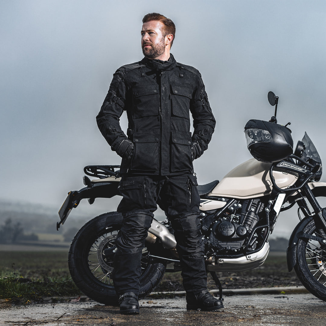 biker wearing full black motorbike gear with black and white motorbike