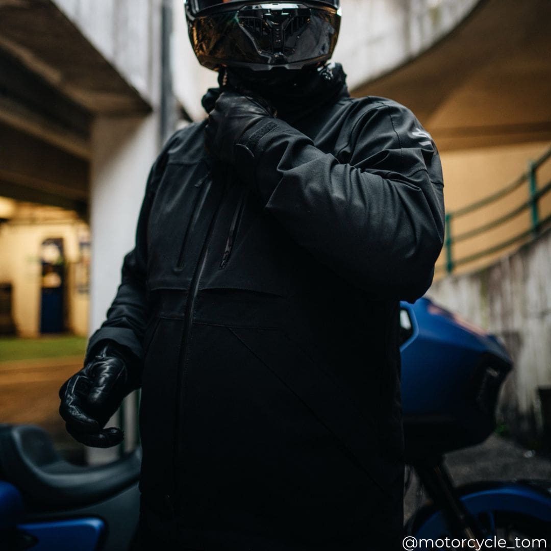 biker in all black motorbike gear including black waterproof motorcycle jacket