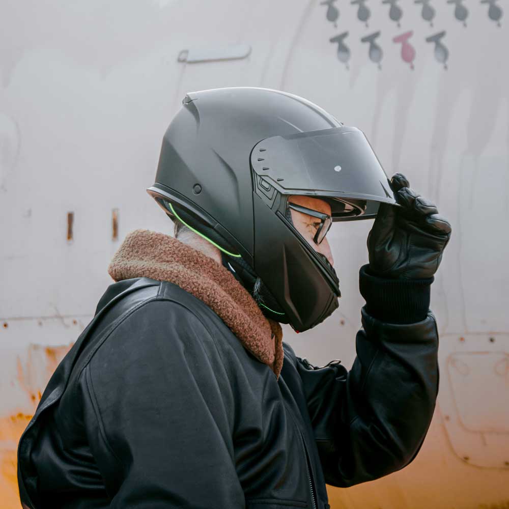 biker wearing black leather jacket for men with black matte motorcycle helmet