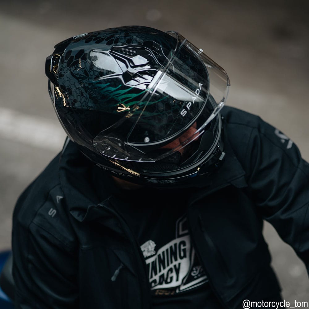 biker wearing black motorcycle helmet with the clear visor flipped up