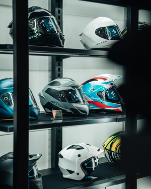 Collection of spada motorbike helmets displays on shelves in store
