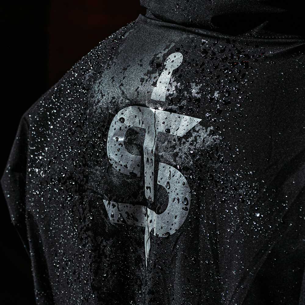 closeup of biker wearing black waterproof motorcycle jacket with reflective logo in the rain