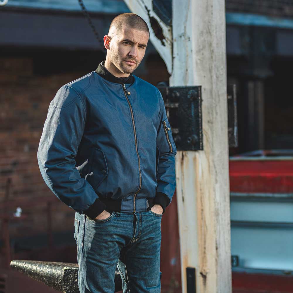 biker wearing blue motorcycle jeans with navy blue motorcycle bomber jacket