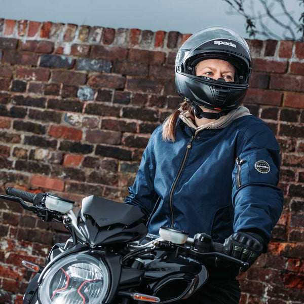 lady biker wearing navy blue bomber jacket for women on motorbike wiht helmet