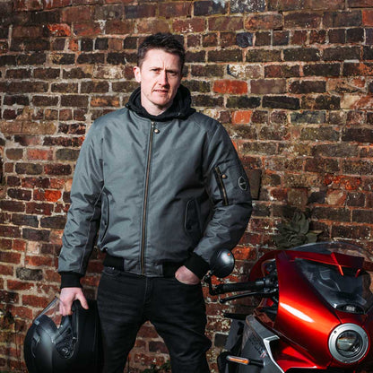 biker wearing grey motorcycle bomber jacket for men with black helmet