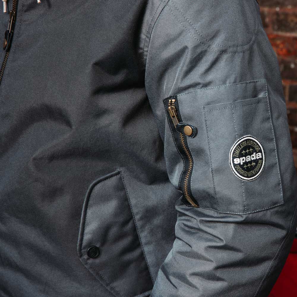 closeup of spada badge on grey bomber jacket for men