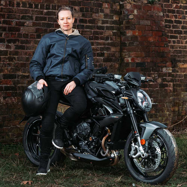 biker girl wearing blue bomber jacket with motorbike gear