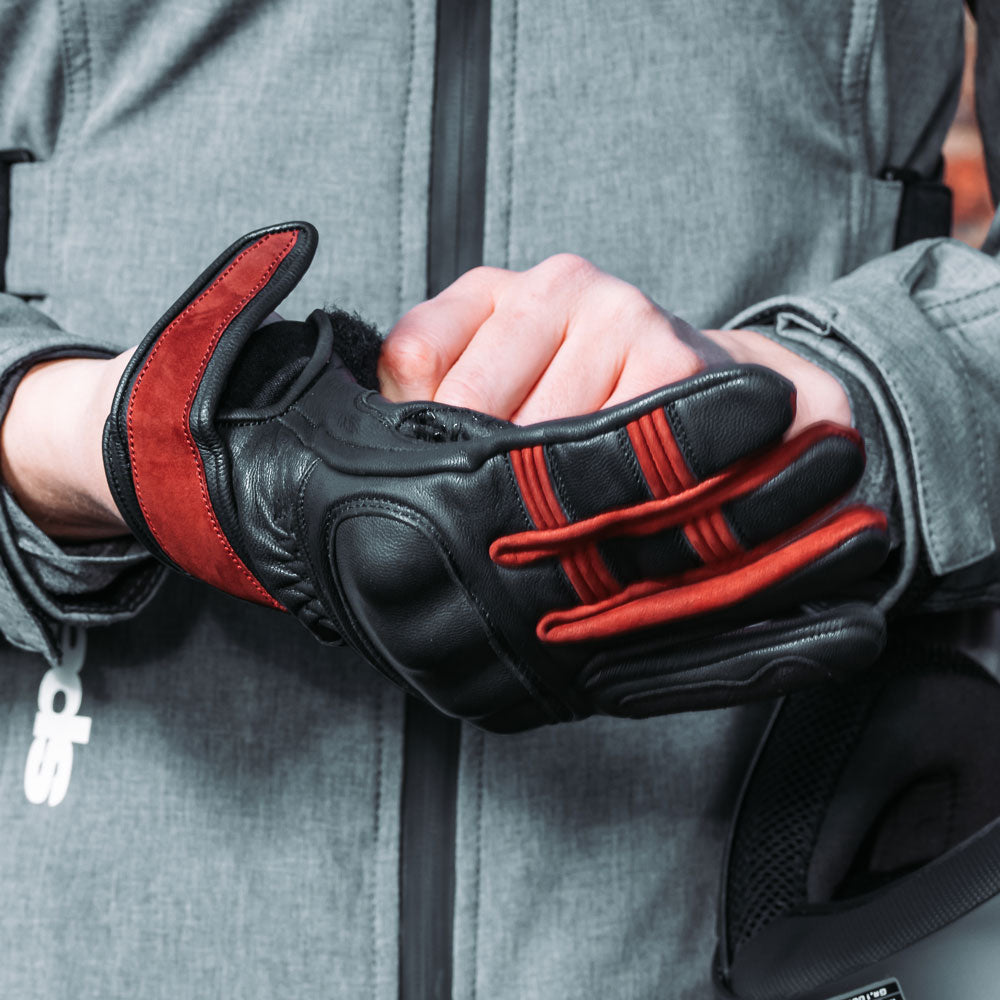 woman biker wearing black leather gloves with burgundy detailing and knuckle protection