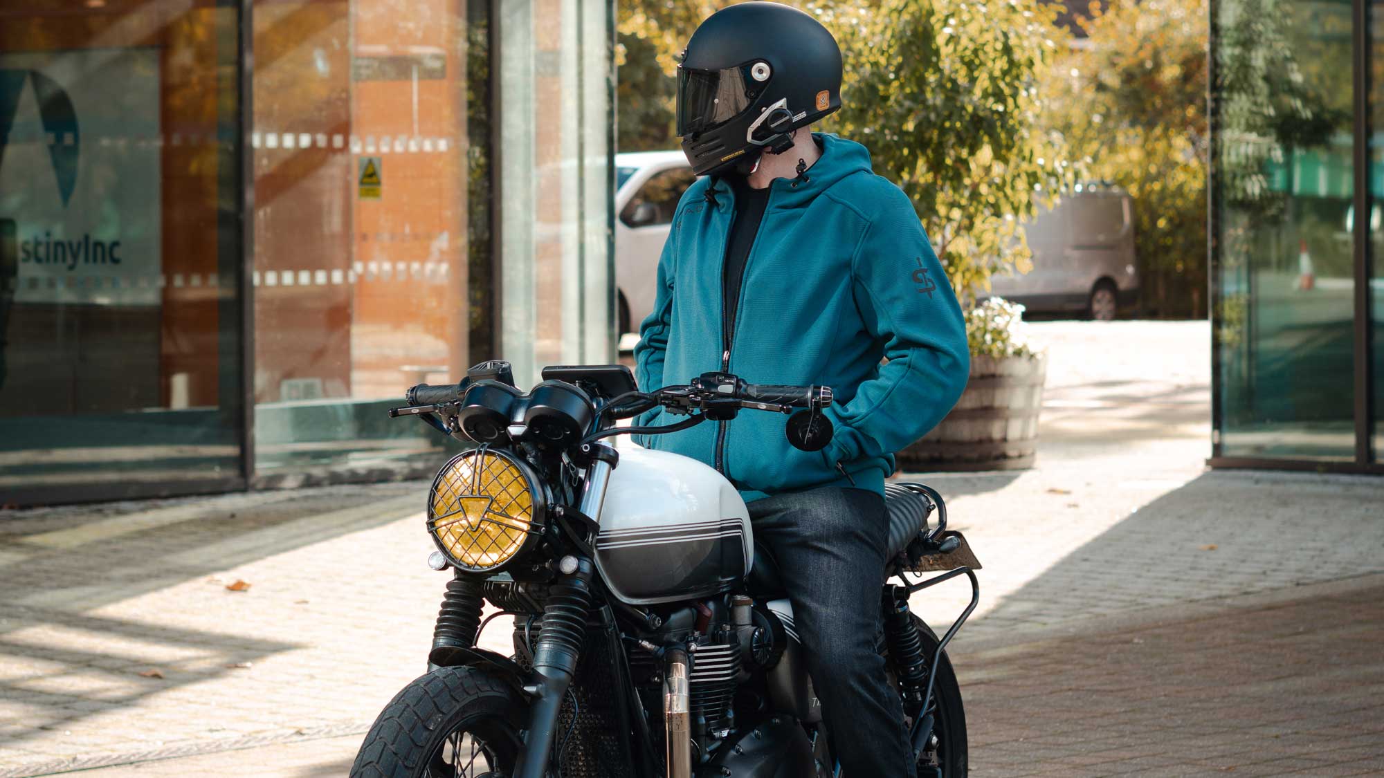 biker on motorbike wearing blue zip up motorcycle hoodie for men with black helmet