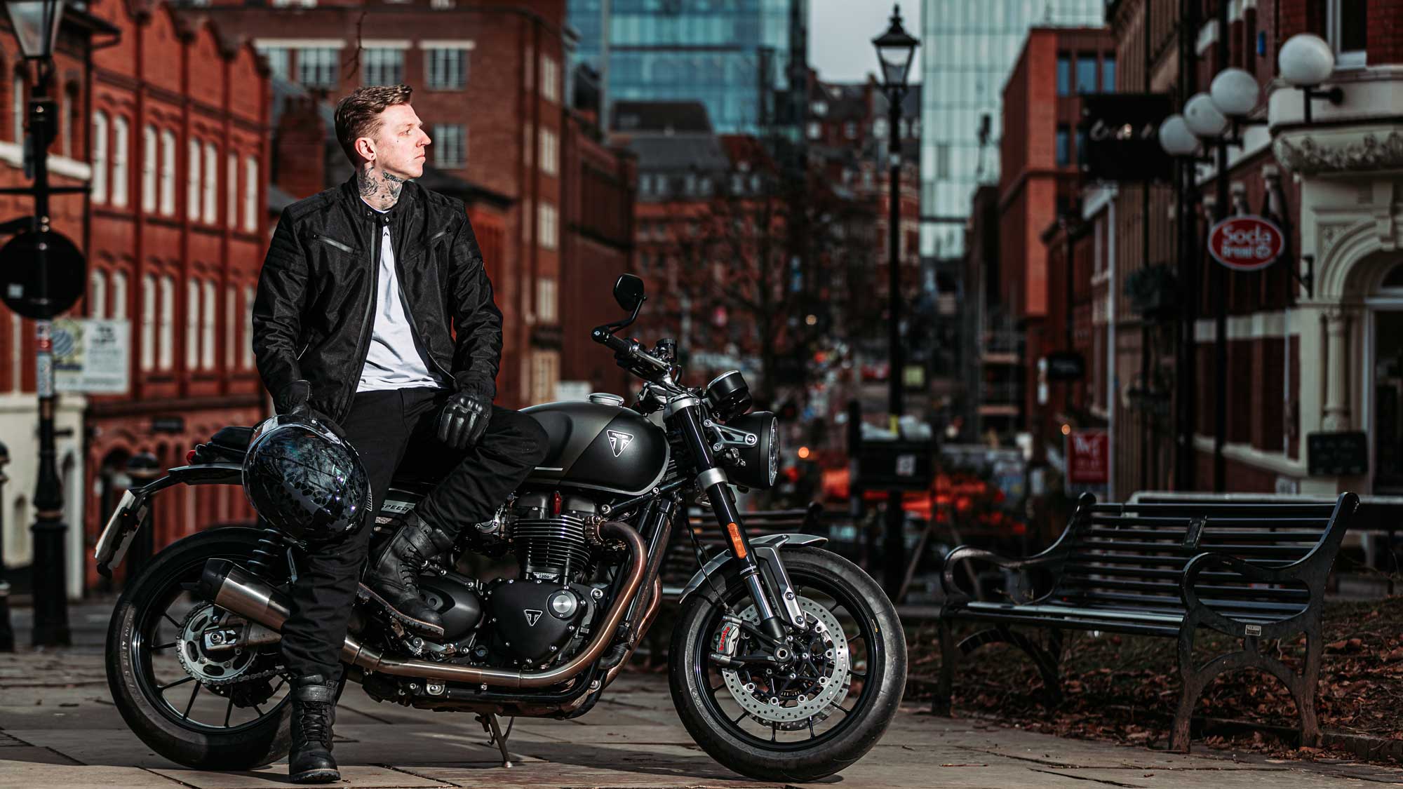 city biker in all black motorcycle gear on black motorbike in the city