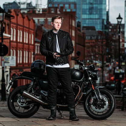 biker wearing black motorcycle gear with black motorbike in the city