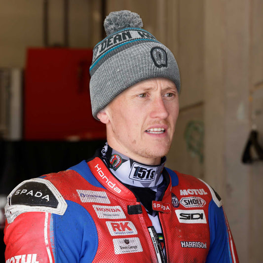 dean harrison after a race wearing a grey marl bobble beanie hat with the DH logo on it