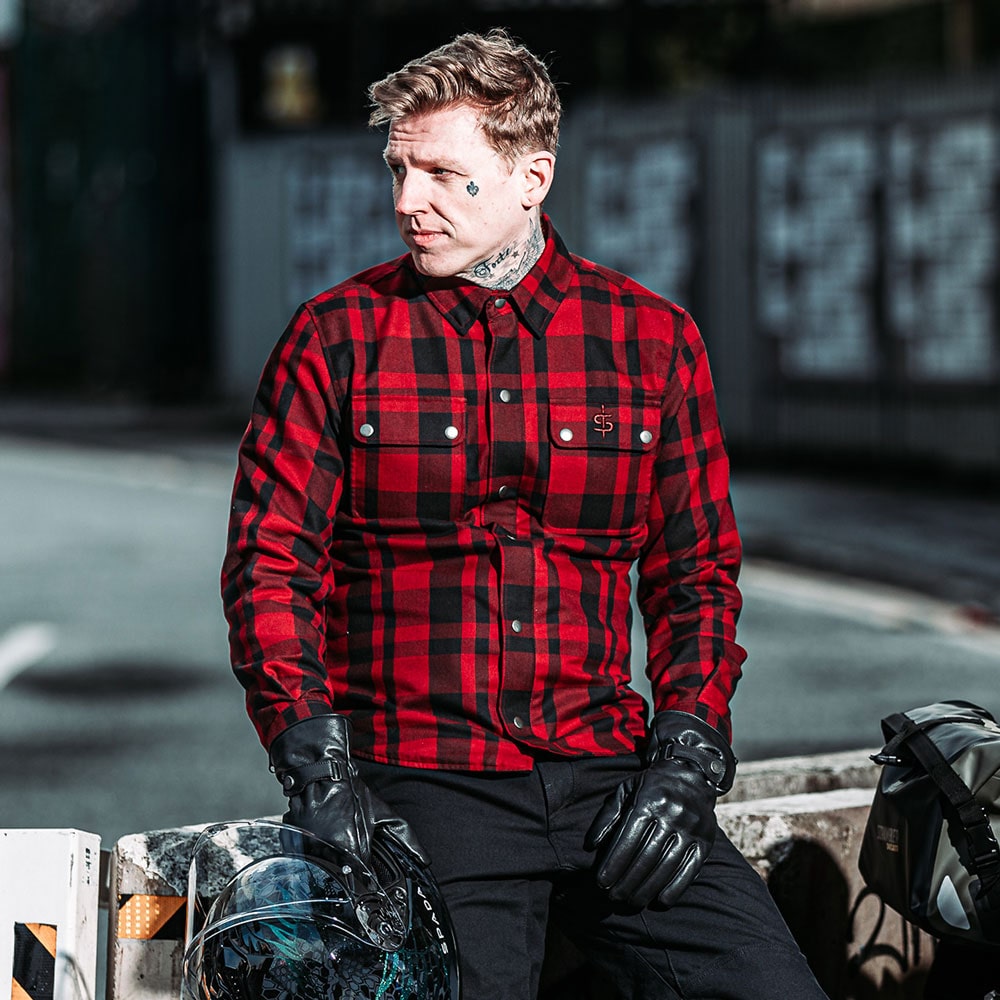 biker wearing black and red motorcycle shirt with black leather gloves and helmet