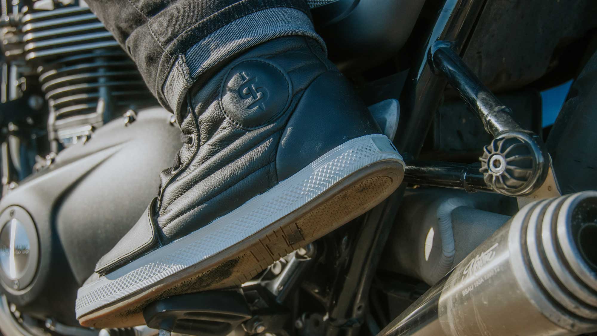 biker wearing black motorcycle boots with ankle protection, waterproof and removable gear shifter on bike