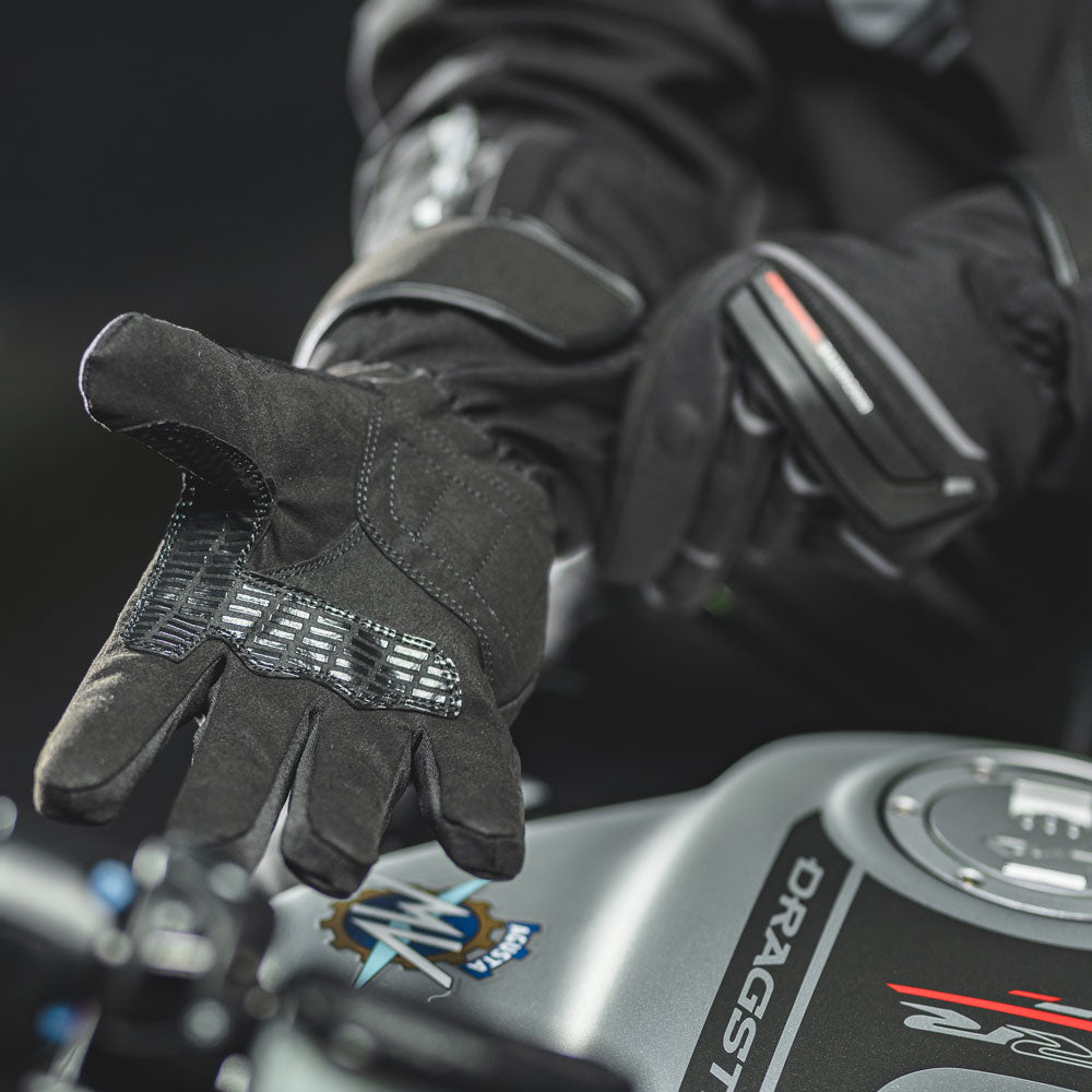 biker putting on black textile waterproof gloves and close up of palm and grip