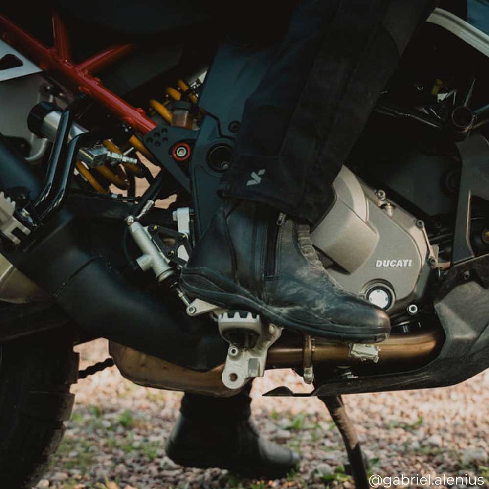 biker girl wearing black motorcycle waterproof boots on motorbike