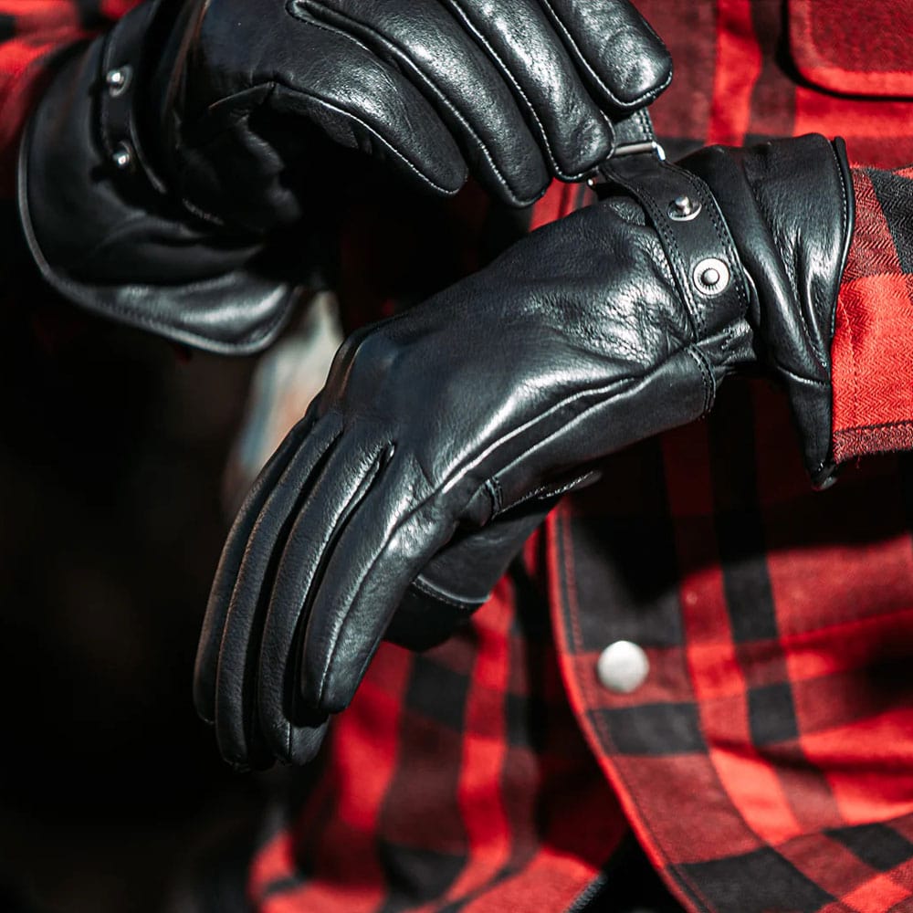 biker wearing black motorcycle gloves for riding with cuff adjustment and red and black motorcycle shirt