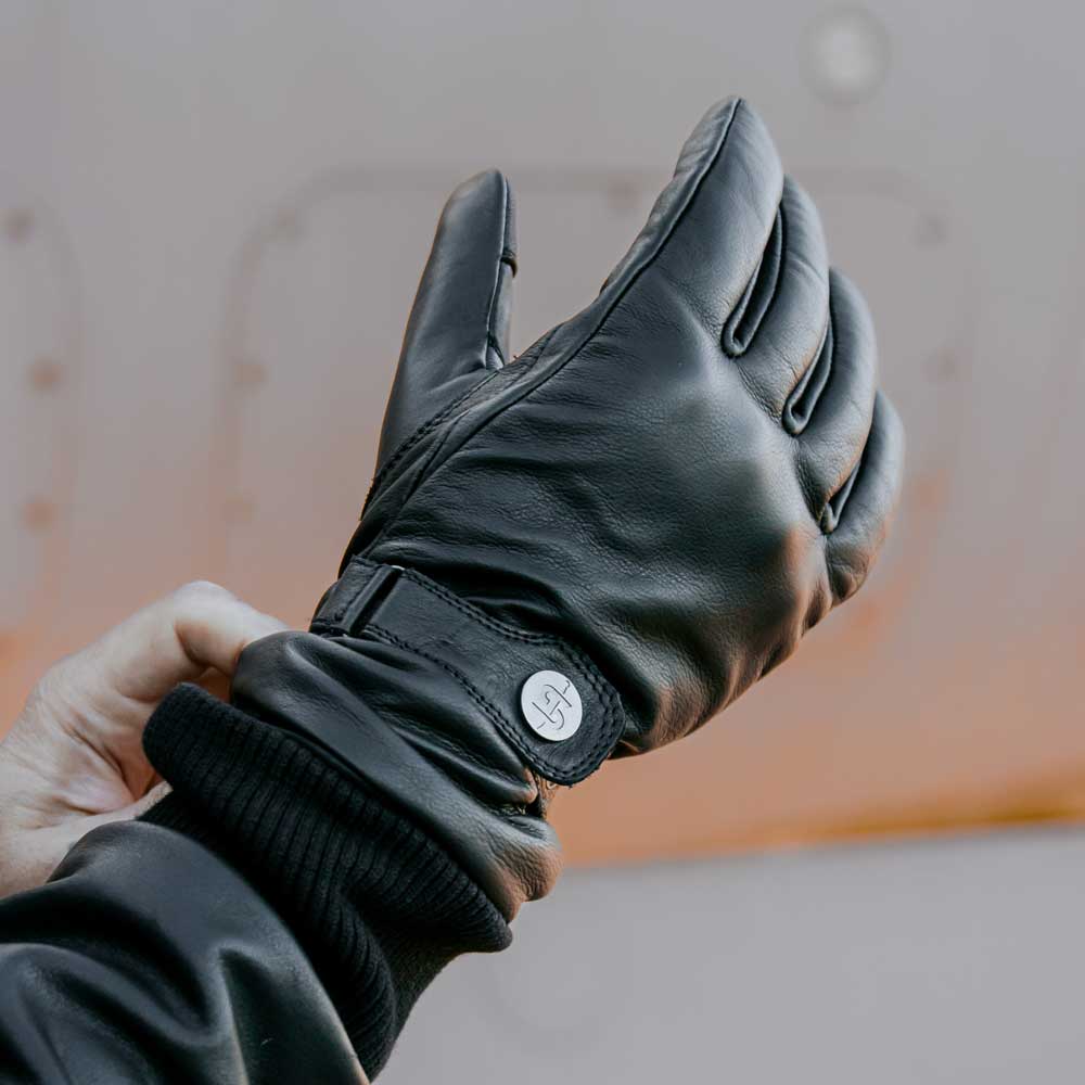 biker putting on black motorcycle leather gloves