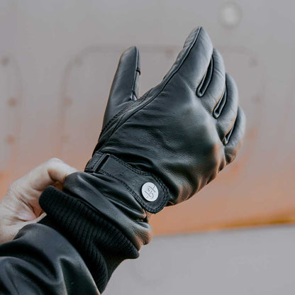 biker putting on black motorcycle leather gloves