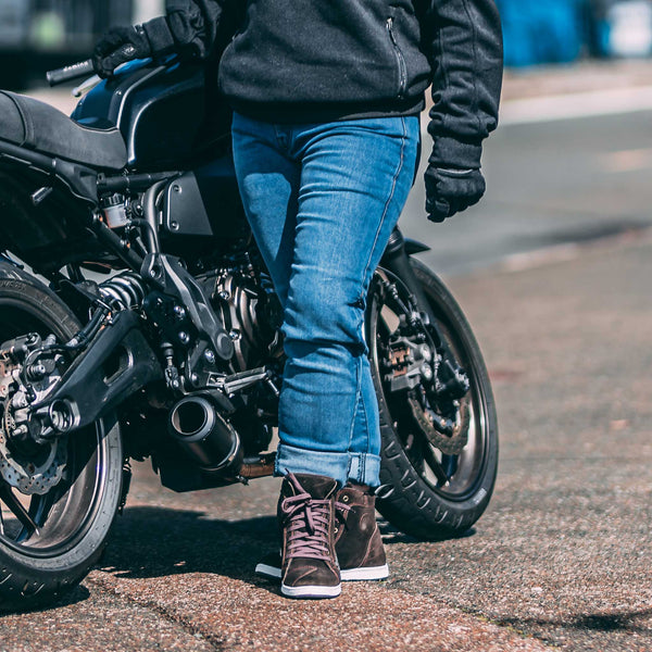 Female rider in Drifters washed blue jeans and brown motorcycle trainers – stylish, protective denim for women bikers