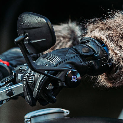 closeup of female biker wearing black leather gloves holding handle bar on motorbike