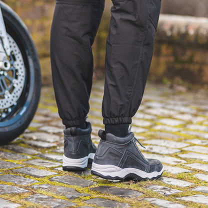 back of cuffed black motorbike trousers for men with grey motorcycle trainers