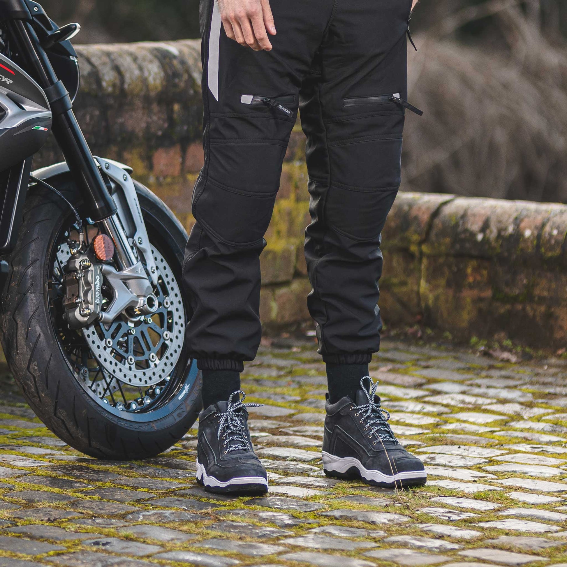 biker wearing dark grey lace up motorcycle trainers with motorbike