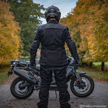 back of biker wearing motorcycle jacket for men with waterproof and detachable elements with helmet and motorbike