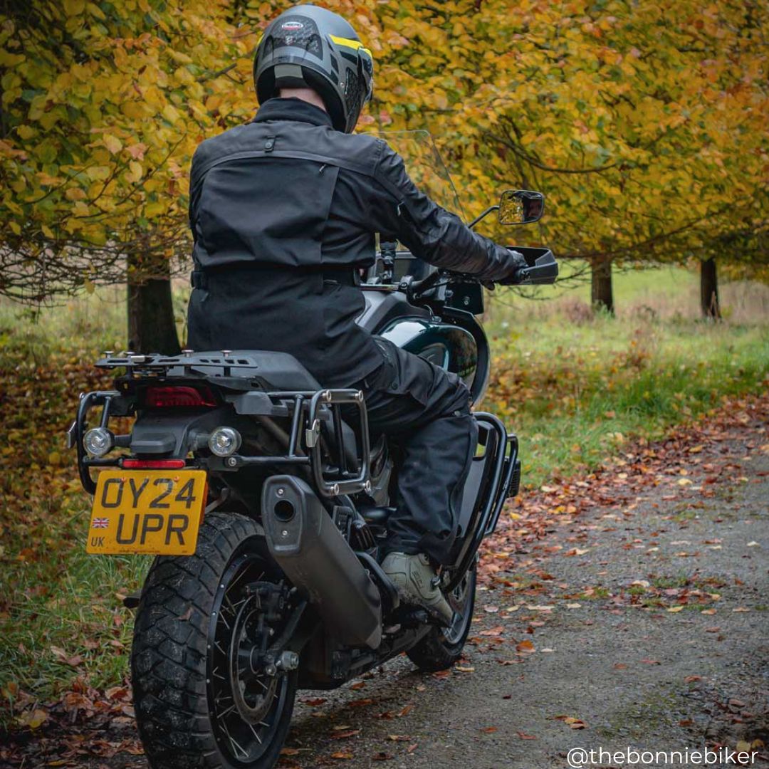 biker riding motorbike while wearing full black motorcycle gear