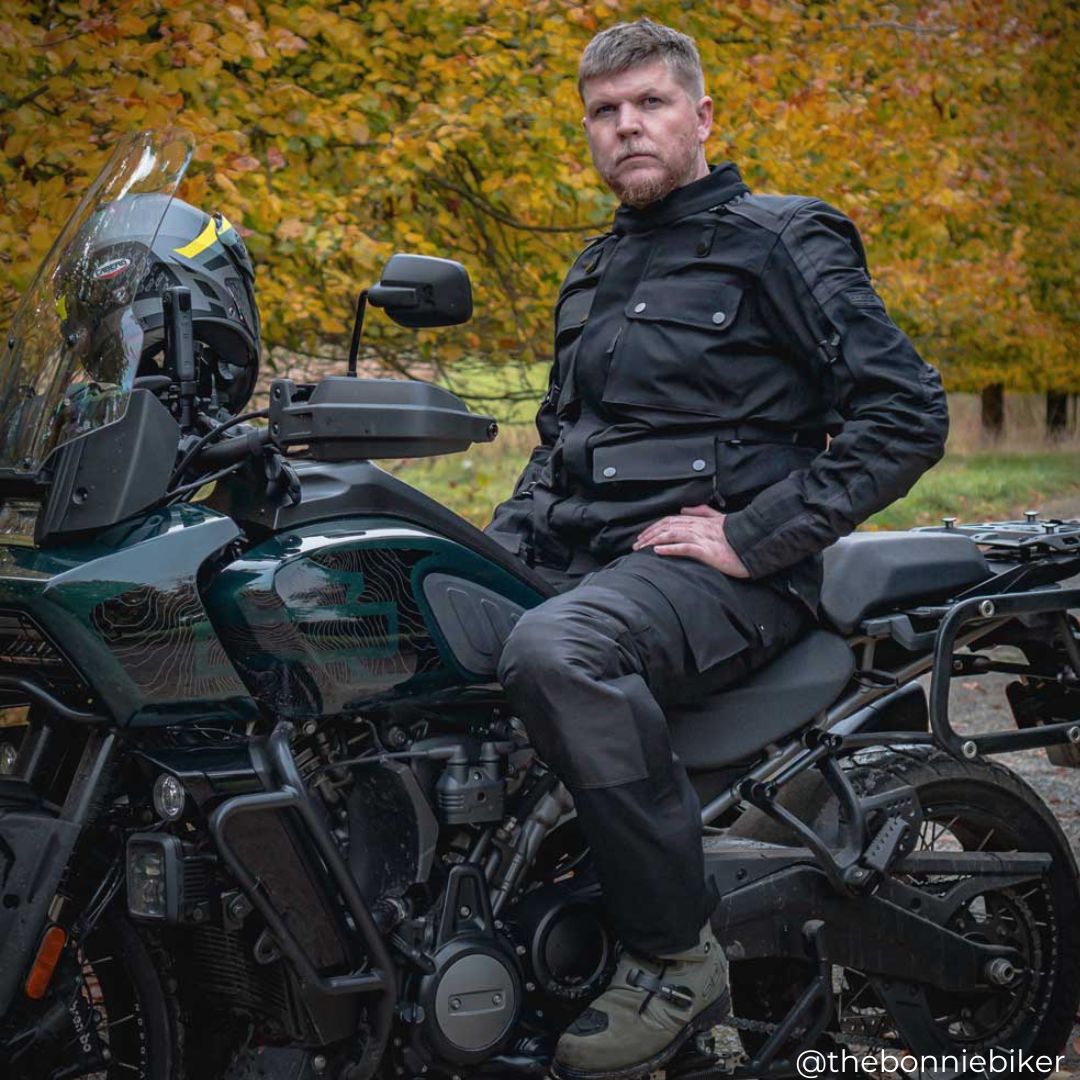 biker on motorbike wearing black motorcycle gear and helmet