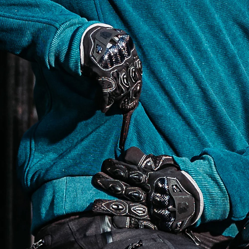 biker wearing black nylon motorcycle gloves and blue motorcycle hoodie