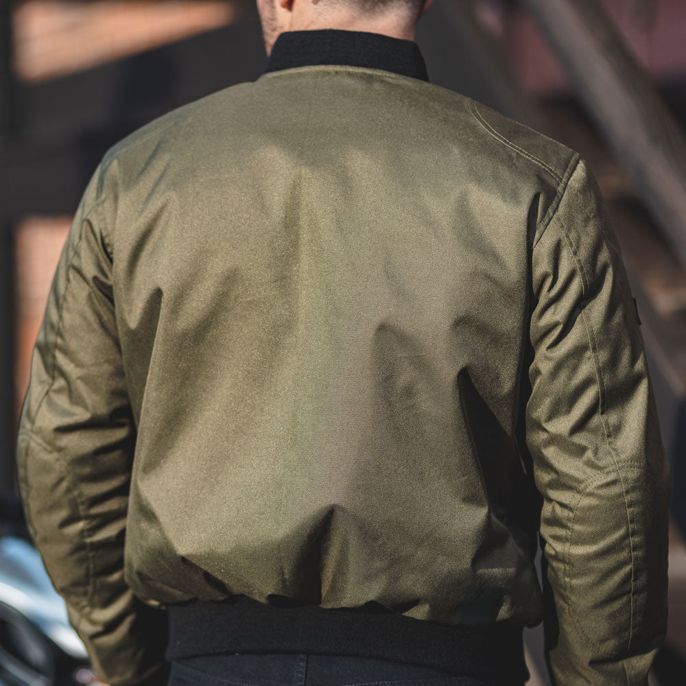 back of olive green motorcycle bomber jacket for men with black ribbed hem and collar