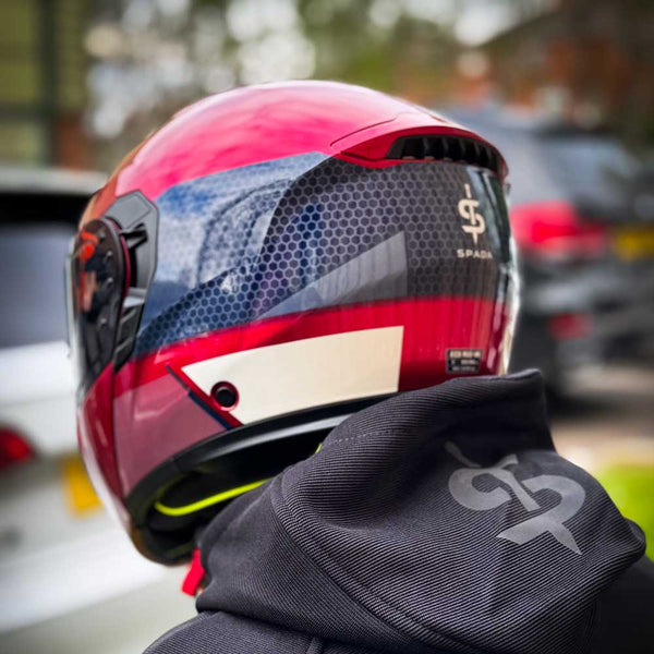 back of red and blue helmet worn by biker paired with black spada hoodie