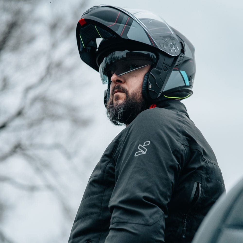 biker wearing black motorbike jacket for men with flip up motorcycle helmet