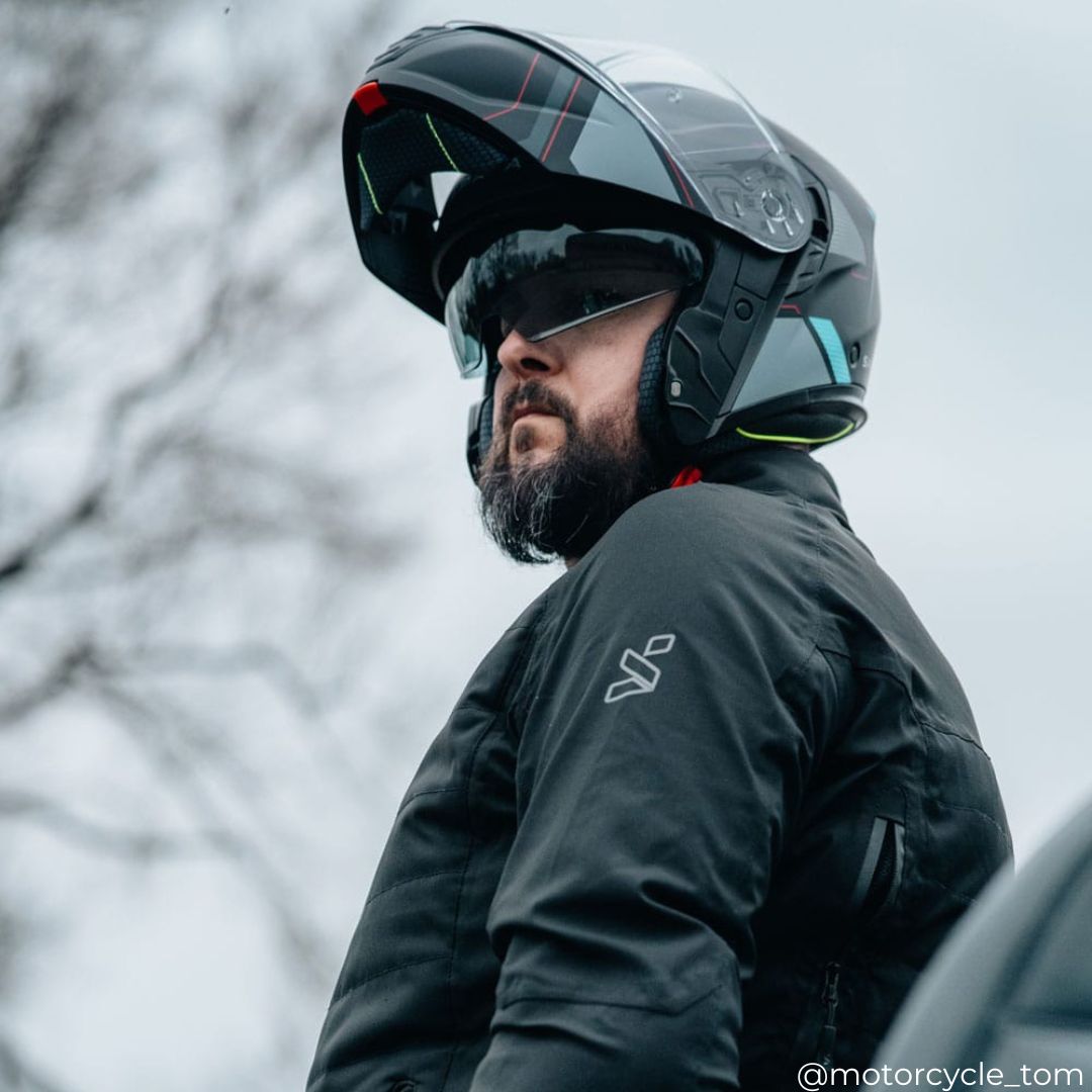 biker wearing black motorbike jacket for men with flip up motorcycle helmet