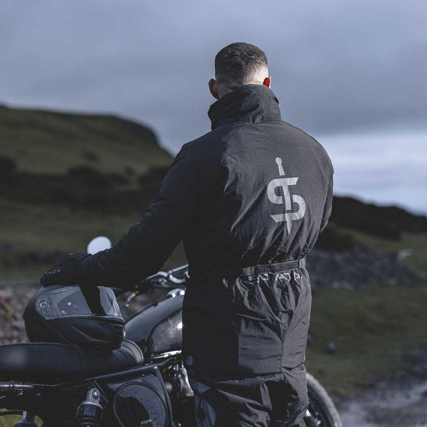 back of biker wearing all black protective motorcycle oversuit onesie