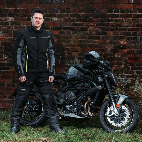 biker with motorbike wearing black and green motorbike jacket