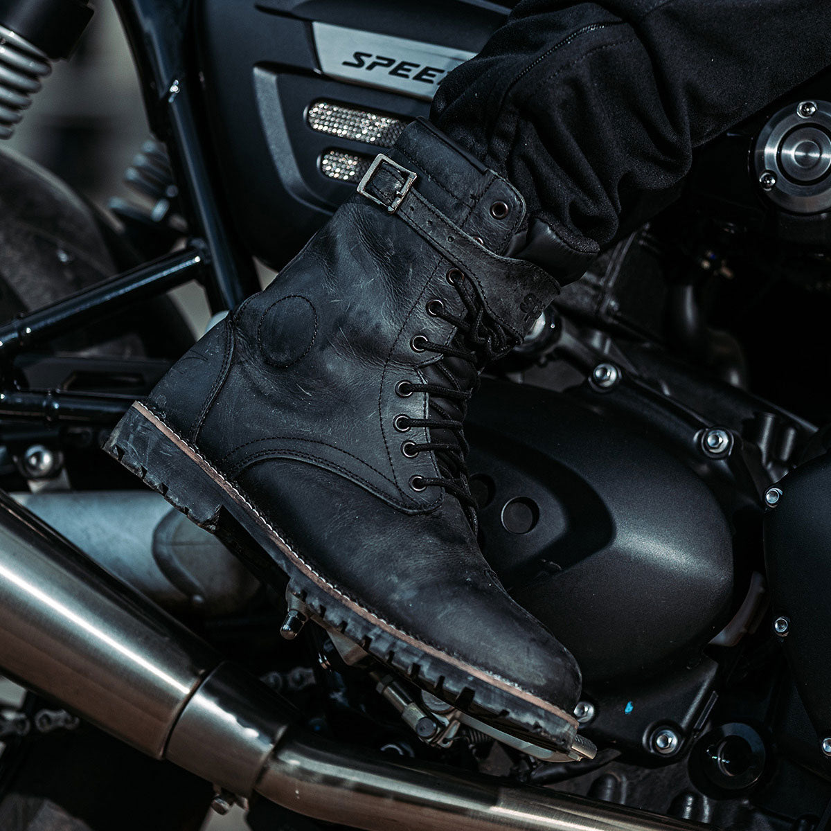 biker wearing black motorcycle boots on motorbike ride