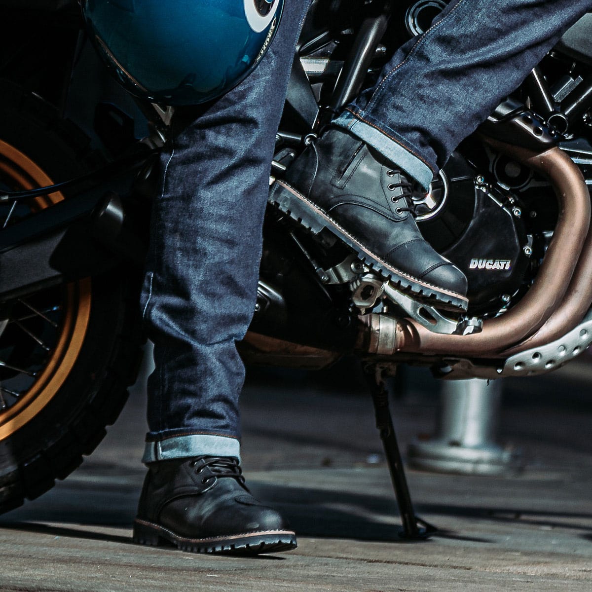 biker wearing black motorcycle boots on a ride with motorbike and motorcycle jeans